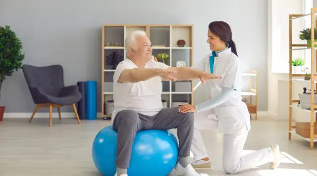 Older Patient balancing with help for a Pain Management Specialist
