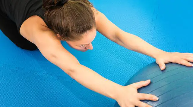 Woman with medicine ball performing Lower Back Pain Relief Exercises